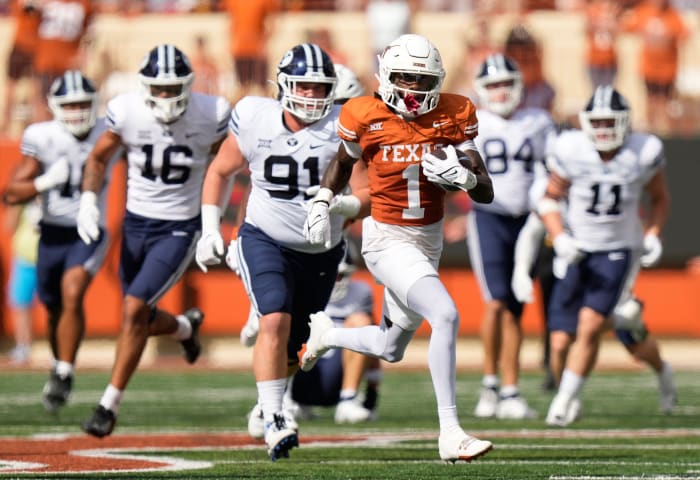 Texas Longhorns Xavier Worthy evades two BYU defenders during a punt return in the first quarter at Royal-Memorial Stadium in Austin.